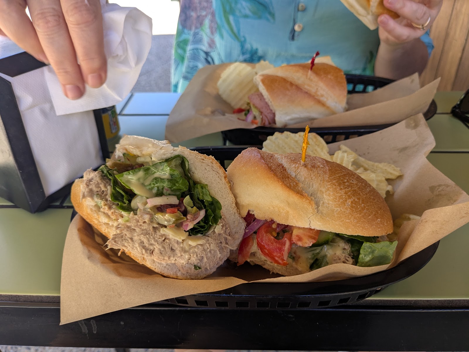 Subs in paper-lined baskets on the table